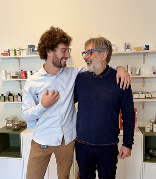 Michele Frosio e Marco Raurati, sorridenti, davanti agli scaffali